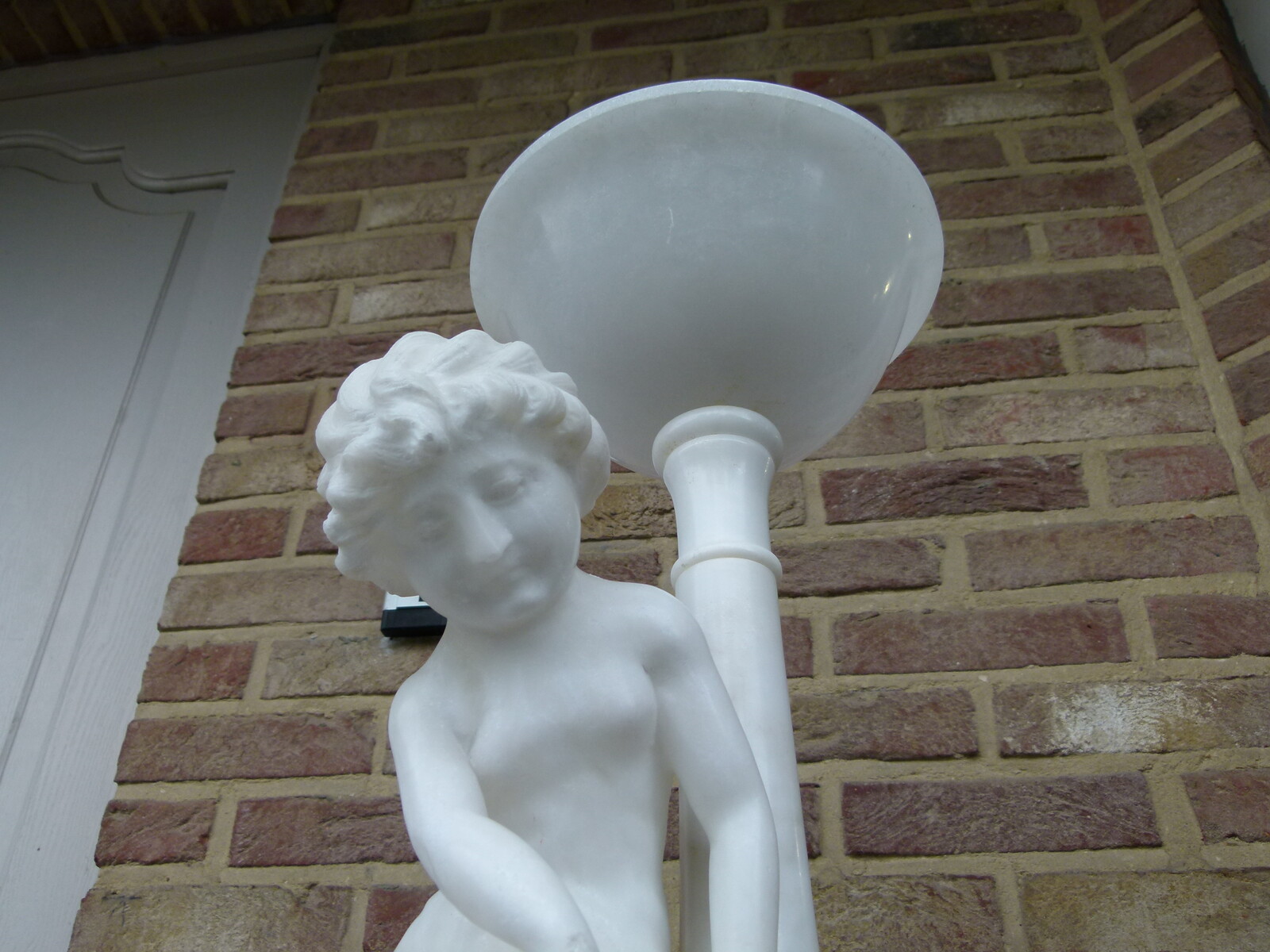 Sculpture and light of a young girl playing with a cat